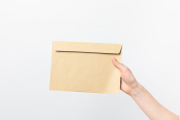 Fototapeta premium partial view of woman holding blank kraft envelope in hand isolated on white