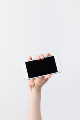 cropped shot of woman holding smartphone with lank screen isolated on white