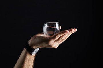 cropped shot of man holding glass of liquid isolated on black