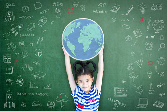 Educated school kid lifting world globe chalk doodle drawing on green chalkboard for education concept