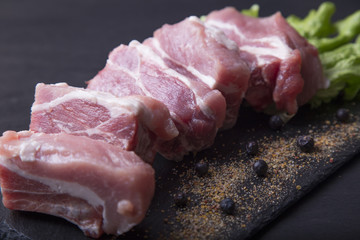 Raw pork meat ribs with ingredients for cooking, dark background
