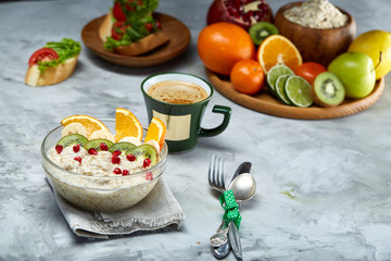 Breakfast still life with oatmeal porridge, fruits and coffee cup, top view, selective focus, shallow depth of field.