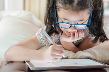 Asian school child girl using smart tablet device digital technology drawing on innovative touchscreen surface