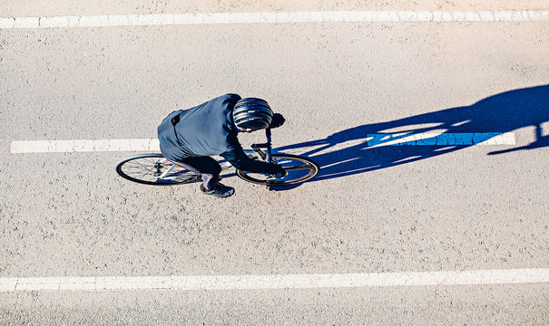 Top view of a man riding a bicycle. Early morning.