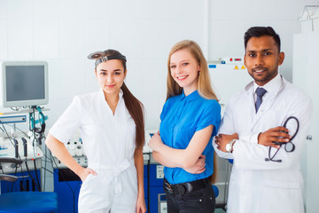 Obraz premium team portrait of a mixed race. Multinational group of medical students. male Asian doctor and white female doctor discuss diagnosis with a young patient.