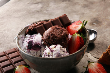 Chocolate coffee ice cream ball in a bowl and strawberry and vanilla