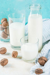 Vegan alternative food, walnut non-dairy milk on light blue background, copy space