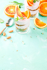 Healthy breakfast, Blood Orange Parfait with granola. yogurt, almond and mint, light blue background, copy space