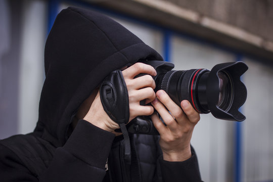 Young man, paparazzi, taking pictures on the street