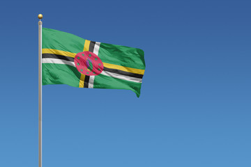 Flag of Dominica in front of a clear blue sky