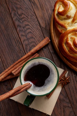 Homemade rose bread, cup of coffee, anise and cinnamon on vintage background, close-up, selective focus