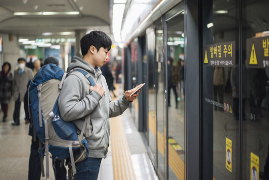 Young man traveling to Korea, male waiting for subway - Powered by Adobe
