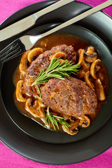 juicy salisbury steaks on black plate