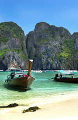 Longtail wooden  Boat  on crystal clear shallow water,  Loh Dalum Beach , Ko Phi Phi , Thailand