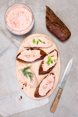 Salmon pate in the glass jar and on pieces of various bread