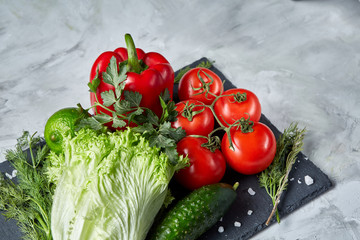 Delicious composition of assorted fresh vegetables and herbs on white textured background, top view, selective focus.