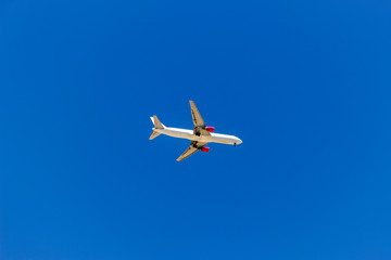 A plane flying in the blue sky without white clouds