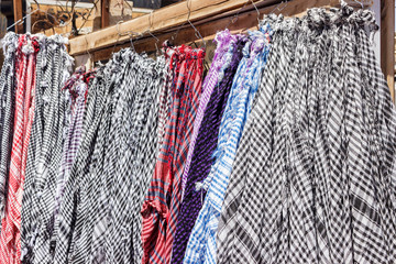 Traditional Keffiyeh or kefia hanging on hangers on bazaar in Egypt