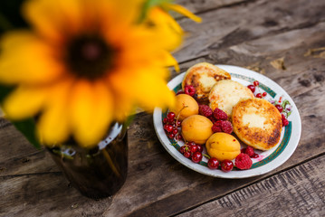 Still-life of flowers and baking with berries on a wooden table.