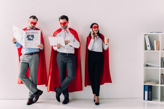 super businesspeople with newspaper, laptop and smartphone in office - Powered by Adobe