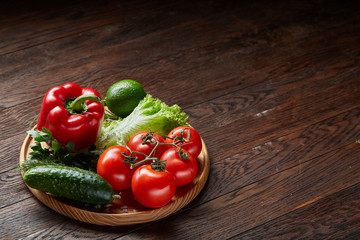 Artistic still life of assorted fresh vegetables and herbs on rustic wooden background, top view, selective focus.