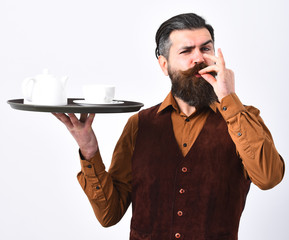 Waiter with white tea cup and pot on tray.