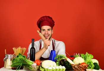 Man in cook hat and apron gets ready to cook