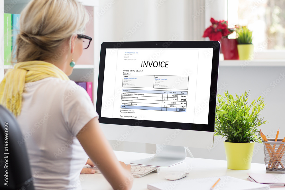 Wall mural woman in office with sample invoice document on computer