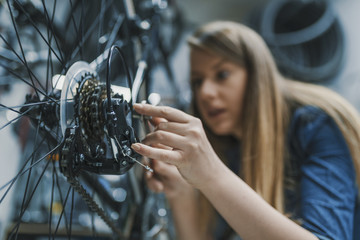 woman bicycle engineer is repairing a bike in the workshop