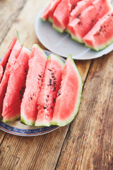 sliced slices of ripe juicy watermelon lie on a plate on a wooden table. small depth of field.