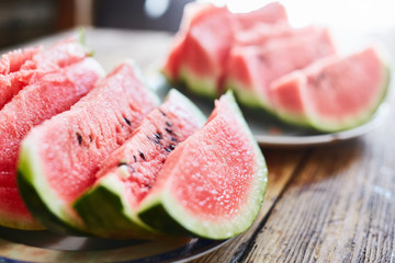 sliced slices of ripe juicy watermelon lie on a plate on a wooden table. small depth of field.