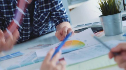 A modern young man participates in a discussion with colleagues. Young and bright contemporary small creative business. Casual young people in architecture or marketing agency company.