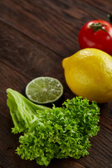 Healthy breakfast with tomatoes, letucce, lime on wooden background, close-up, selective focus, top view.