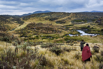 Traditional Masai and Ranger hiking in crater moutain