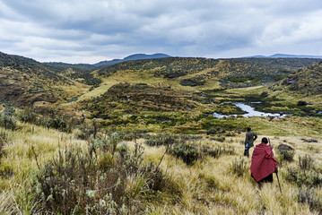 Traditional Masai and Ranger hiking in crater moutain