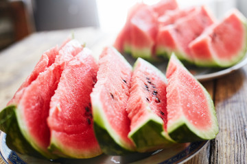 sliced slices of ripe juicy watermelon lie on a plate on a wooden table. small depth of field.