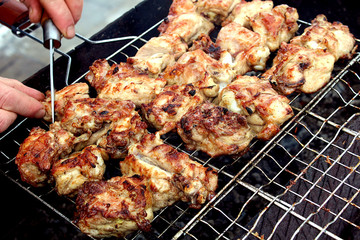 frying pieces of meat in a barbecue on the street