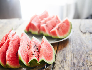 sliced slices of ripe juicy watermelon lie on a plate on a wooden table. small depth of field.