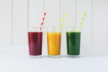 Detox drinks in glass: fresh smoothies from vegetables: beet, pumpkin and spinach on white background