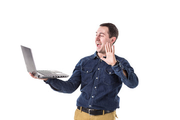 young programmer (man) holding a laptop in hands and talking on skype with friends isolated on...