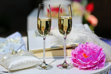 Two glasses filled with champagne with flowers.