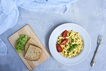 Scrambled eggs in plate on rustic background