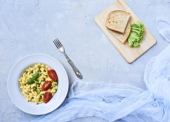 Scrambled eggs in plate on rustic background