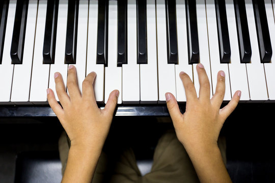 hands of kid playing piano