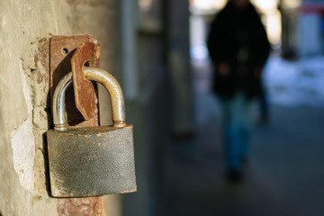 Old iron padlock hanging at open gate