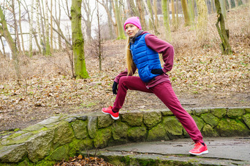 Sporty girl stretching outdoor in park.