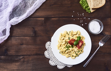Scrambled eggs in plate on rustic background