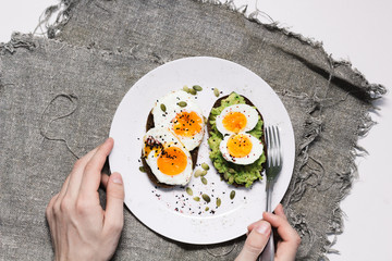 sandwich with fresh vegetables, avocado, hard-boiled eggs and pumpkin seeds with olive oil and...