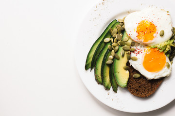 sandwich with fresh vegetables, avocado, hard-boiled eggs and pumpkin seeds with olive oil and bread. healthy diet or vegetarian food on a white background. salad with yolks on toast. top view