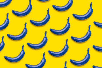 Fototapeta na wymiar Colorful fruit pattern of fresh blue bananas on yellow background. From top view